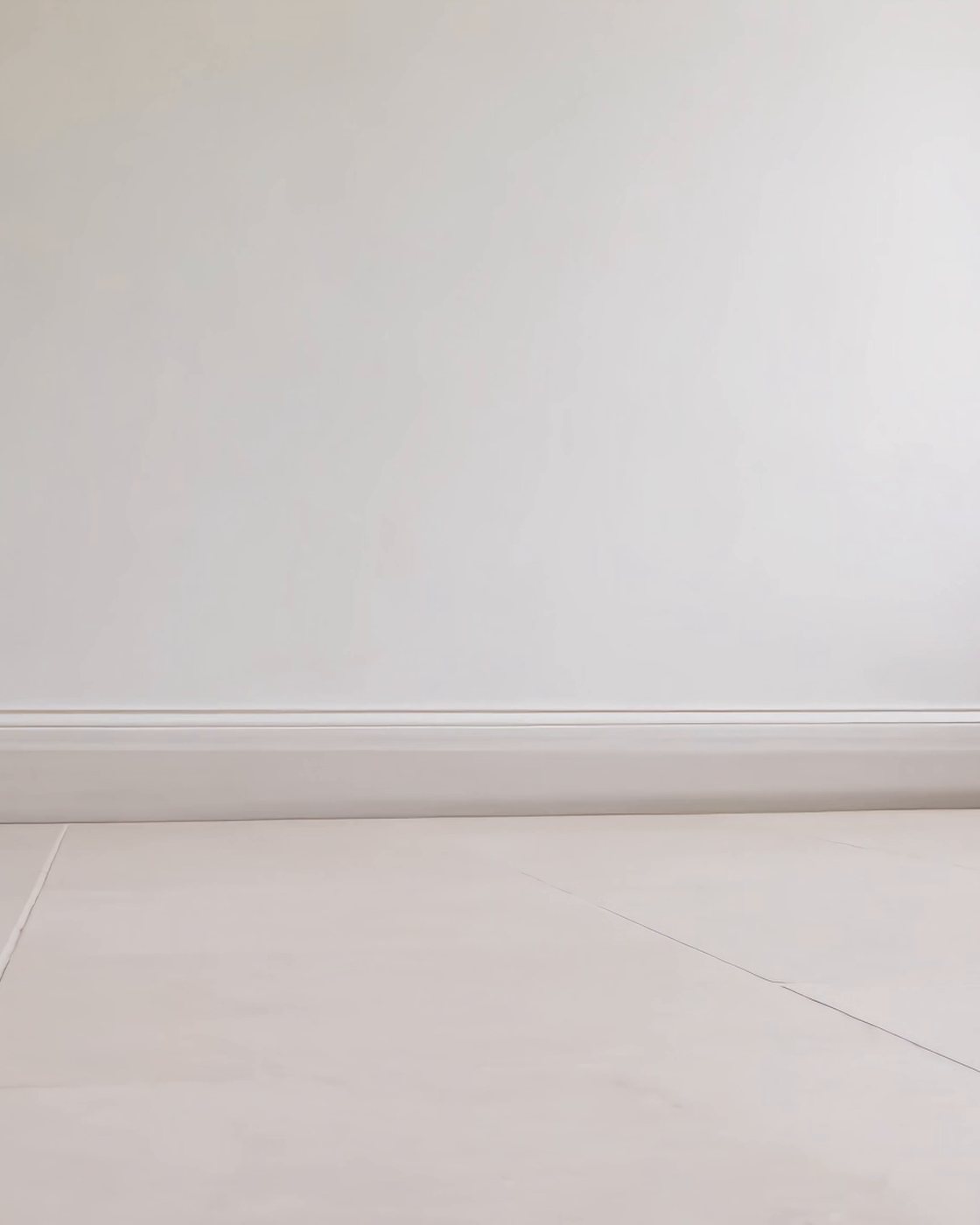An empty, freshly plastered room with a sash window, waiting for its furniture