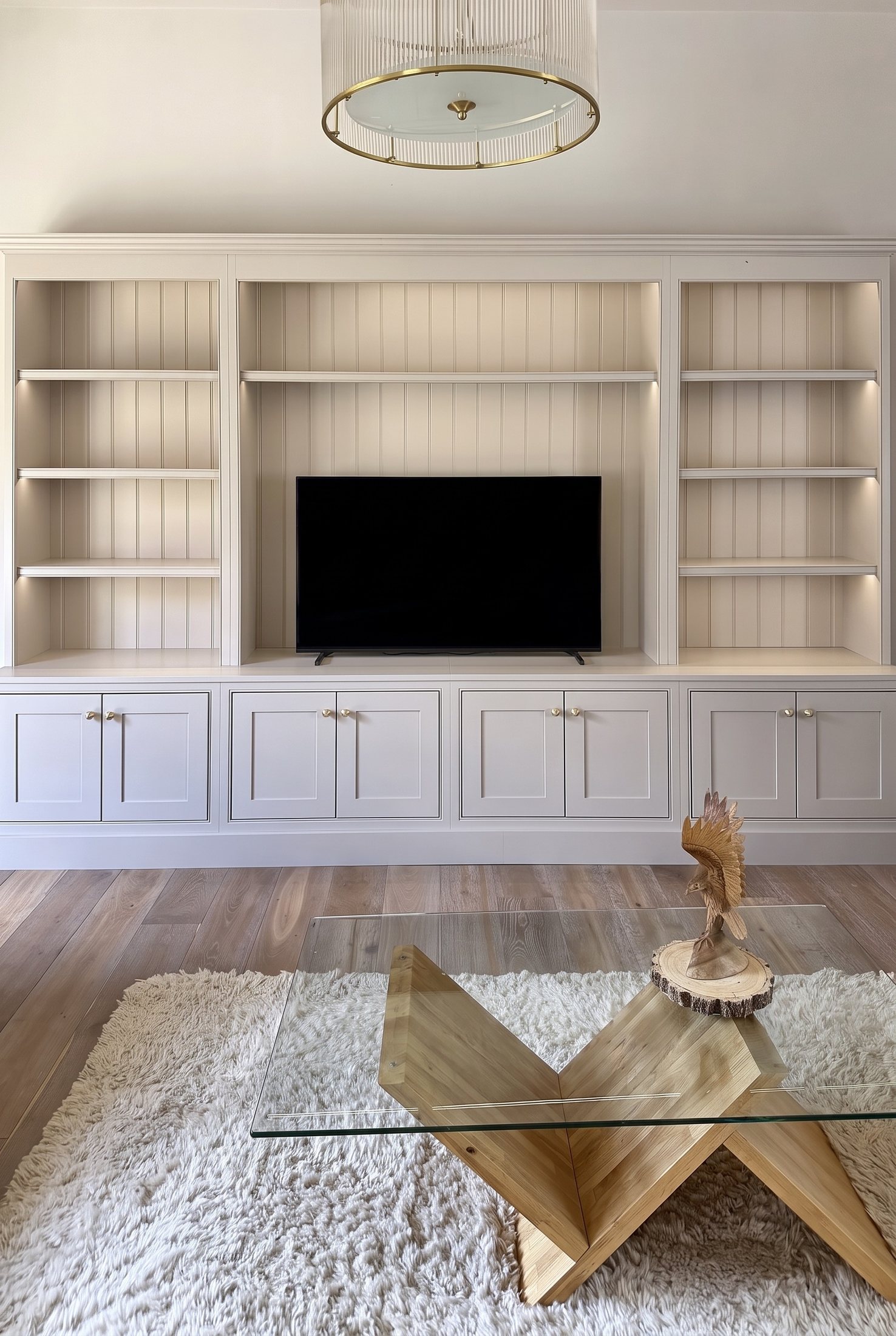 A painted bookcase and media unit filling the wall of a living room