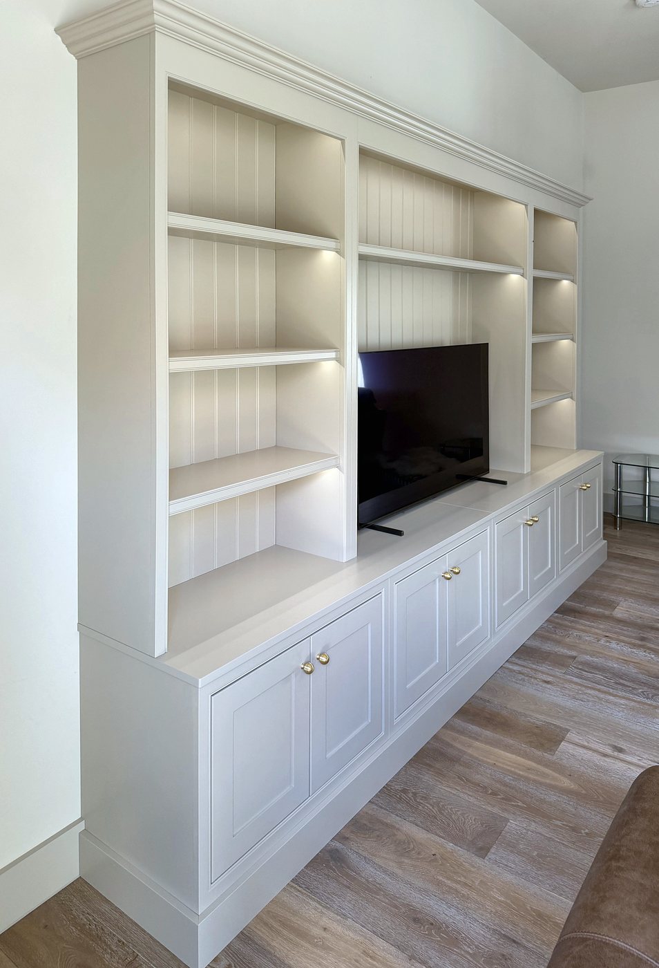 The bookcase run with brass knobs on the cupboards below