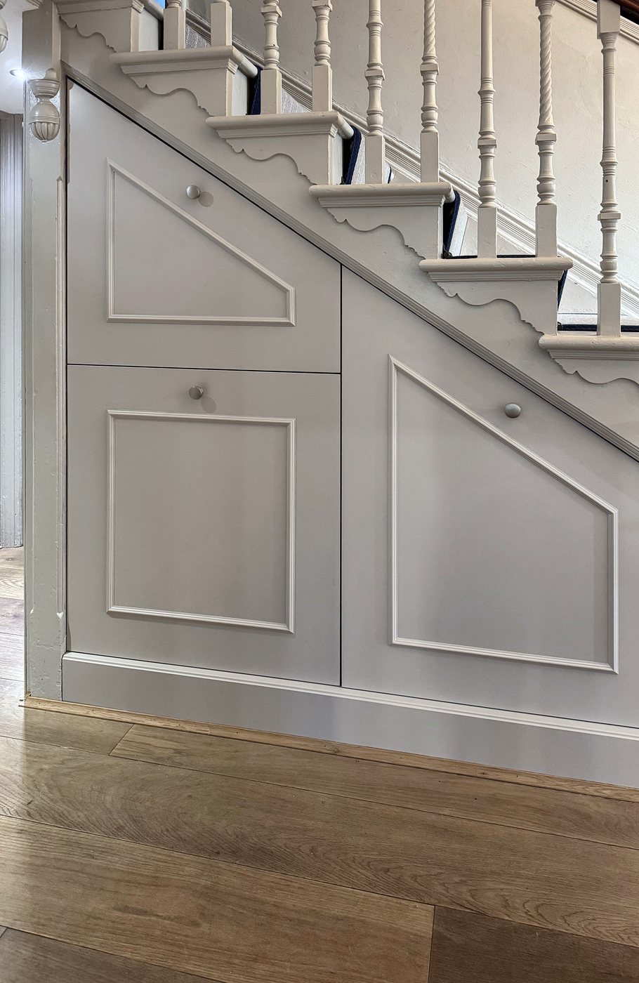 The panelled under-stairs storage seen along the hallway