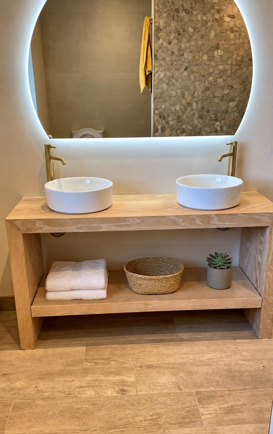 Floating oak waterfall vanity with two countertop basins, brushed brass taps and an open shelf below