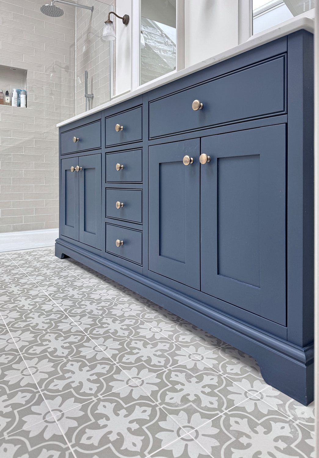 The navy double vanity from the side, showing its drawers and plinth