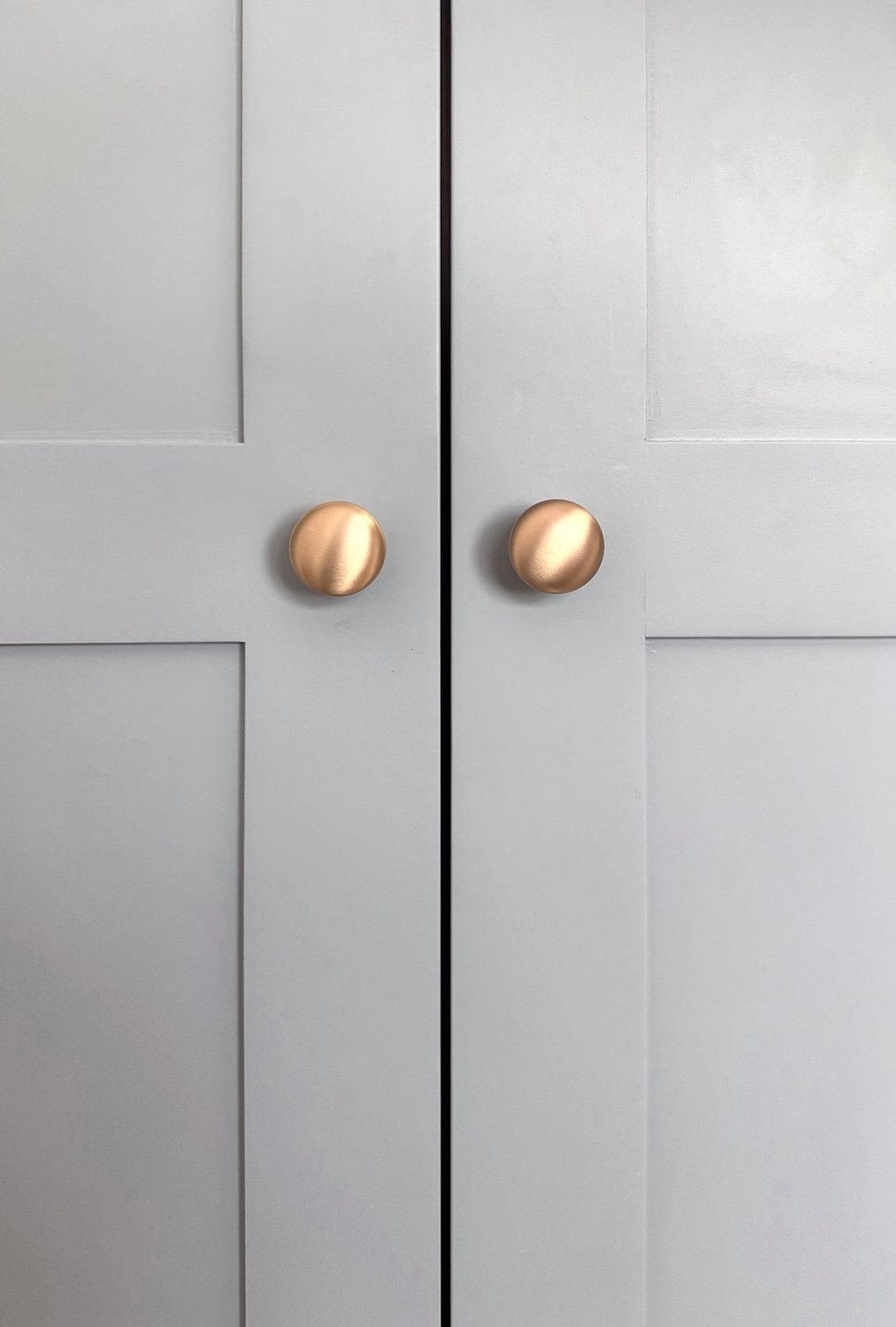 Close view of brass knobs on painted shaker doors