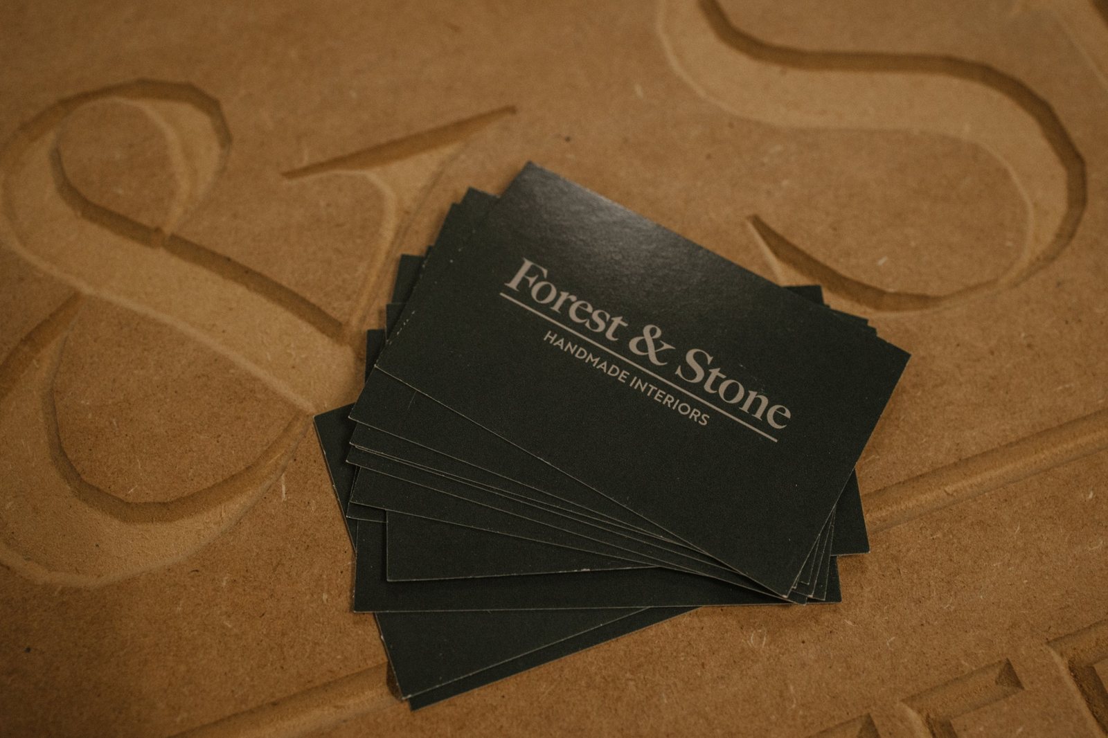 Forest & Stone business cards on a carved panel in the workshop