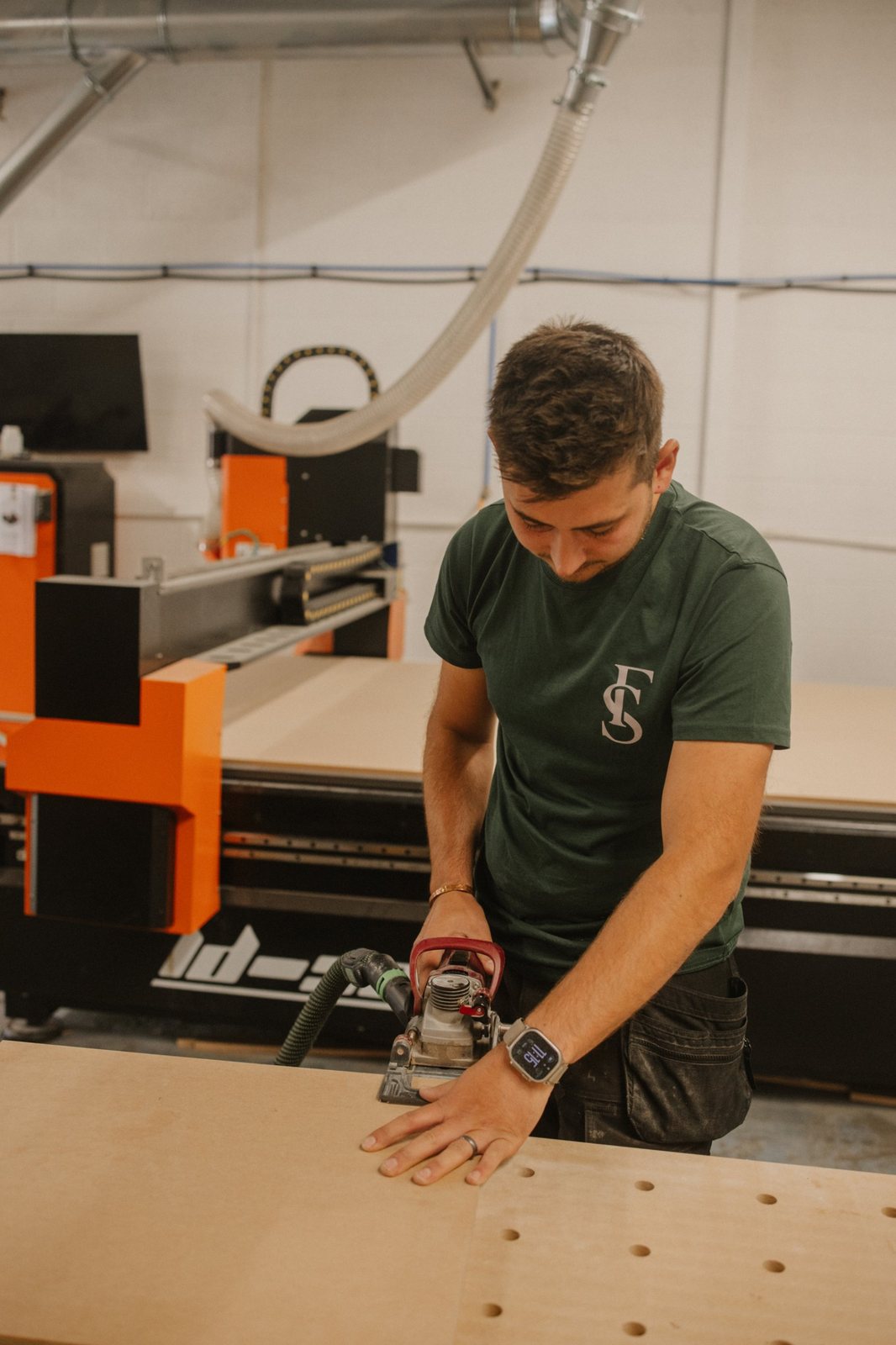 Cutting joints into a panel at the bench, with the CNC router behind