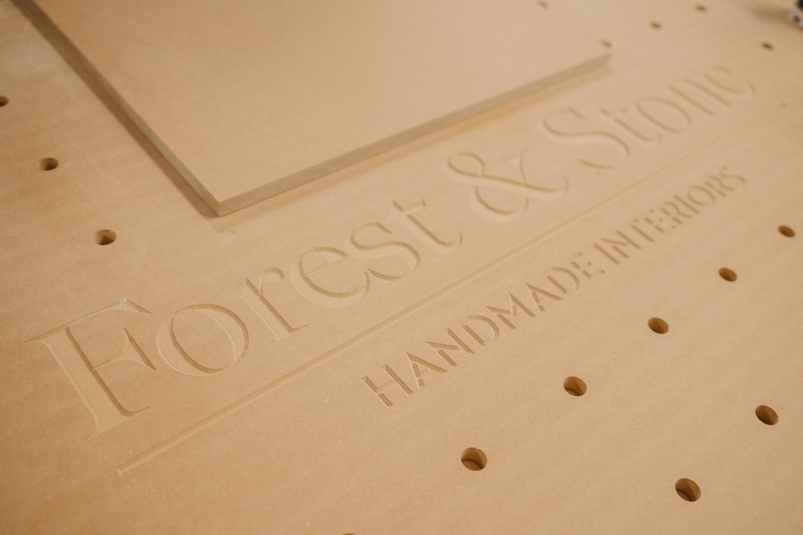 Forest & Stone, Handmade Interiors, carved into a panel on the workshop bench