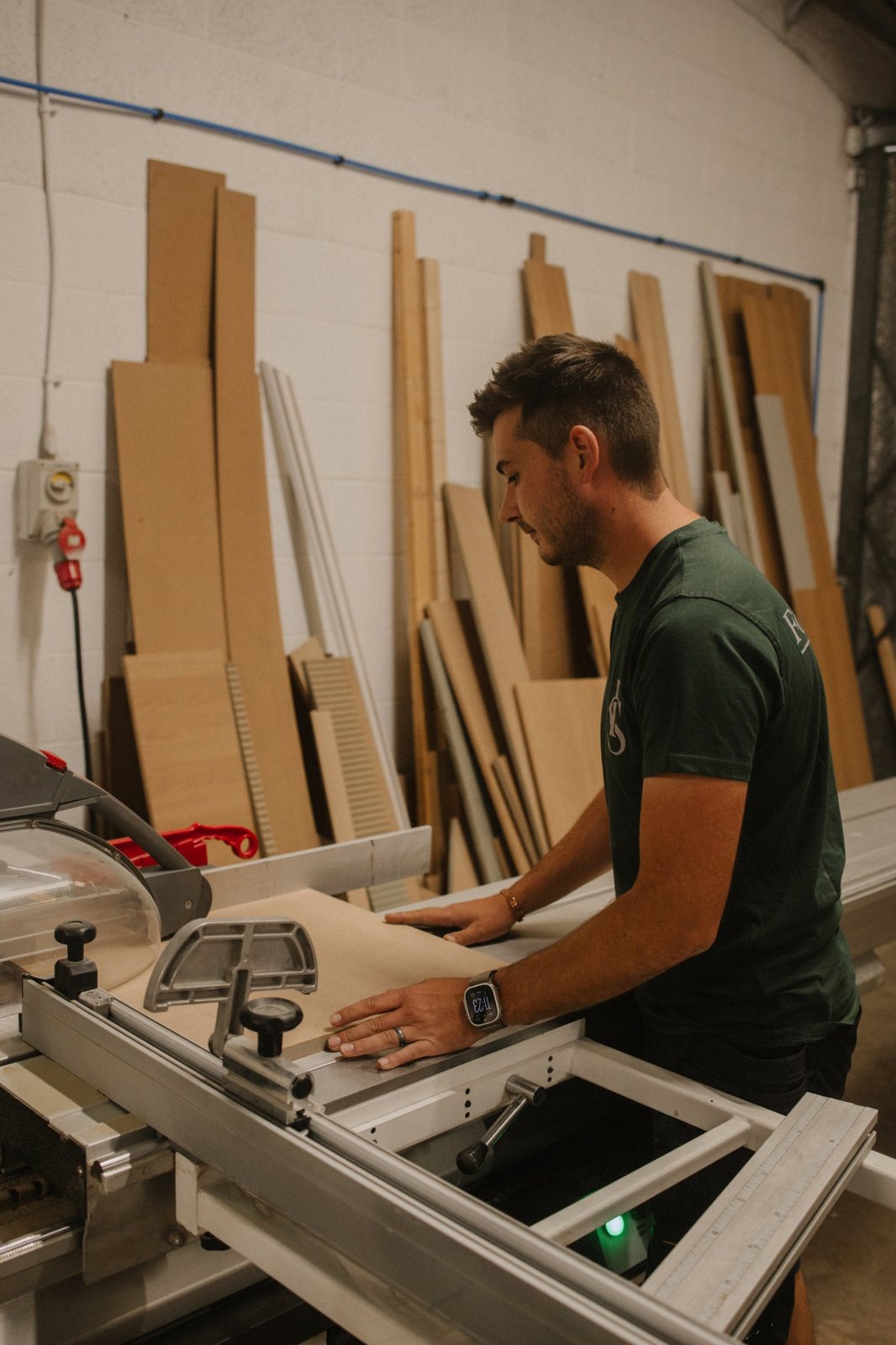 Cutting a sheet on the panel saw in the Forest & Stone workshop, with offcuts stacked against the wall